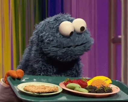 A GIF of cookie monster choosing between options